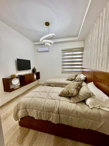 a bedroom with a large bed and a flat screen tv at Brisamar La Paz- Terraza Vista al Mar - Cerca del Malecon in La Paz