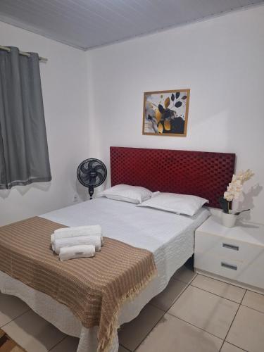 a bedroom with a bed with a red headboard at Casa ampla e confortável em Cruz das Almas in Cruz das Almas