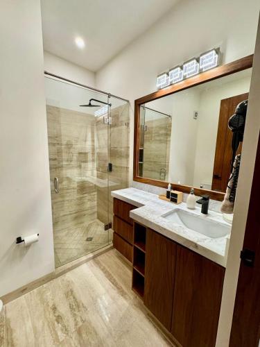 a bathroom with a shower and a sink and a mirror at Brisamar La Paz- Terraza Vista al Mar - Cerca del Malecon in La Paz