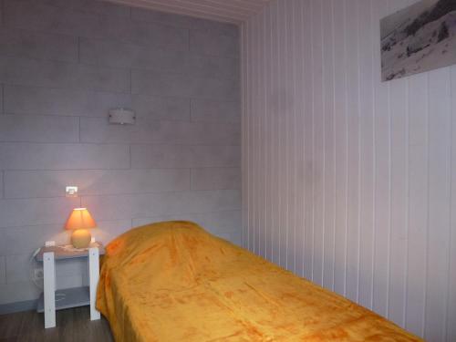ラ・ブレスにあるLa Bresse Hautes Vosges Chalet Le Podentのベッドルーム1室(ベッド1台、ランプ付きテーブル付)
