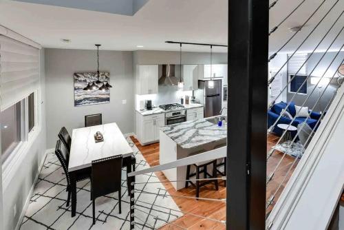 a kitchen and living room with a table and chairs at Modern Townhome Near Downtown walk to CWS! in Omaha