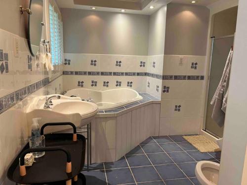 a bathroom with a tub and a sink and a toilet at Chalet Style, Lakeview Cottage in Bailieboro