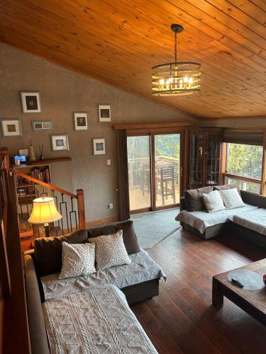 a living room with a couch and a table at Chalet Style, Lakeview Cottage in Bailieboro