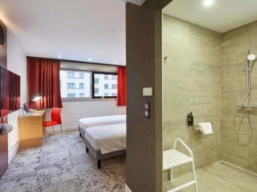 ein Hotelzimmer mit Bett und Dusche in der Unterkunft ibis Annemasse-Genève in Ambilly