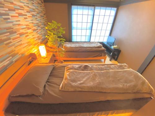 a bedroom with two beds and a window at Sea Hale - Vacation STAY 7734 in Yuzawa