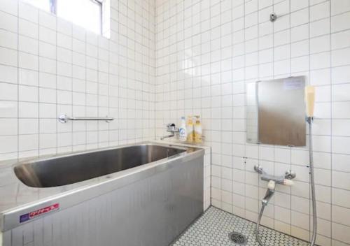 a bathroom with a sink in a tiled wall at Yuzawa Kodate - Vacation STAY 9495 in Yuzawa