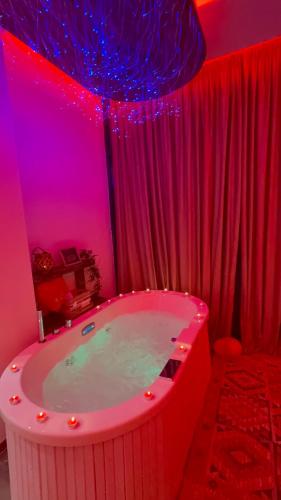 a bathroom with a bath tub with red lighting at Bujtina Kael in Librazhd