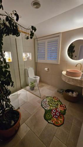 a bathroom with a shower and a toilet and a rug at Bajo el Sol in Nelson
