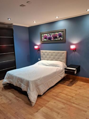 a bedroom with a bed and a blue wall at Casademontaña in Belén