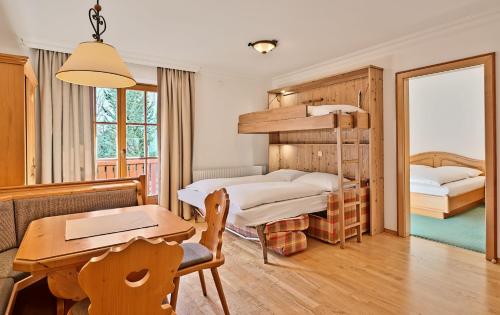 1 Schlafzimmer mit 2 Etagenbetten und einem Tisch in der Unterkunft Appartementhaus Alpenpark in Großarl