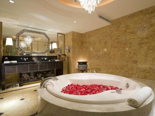 a bathroom with a tub filled with red roses at Sofitel Harbin in Harbin