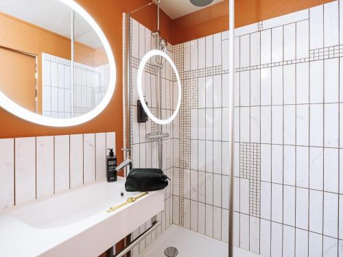 a bathroom with a tub and a mirror at ibis Styles Le Mans Gare Sud in Le Mans
