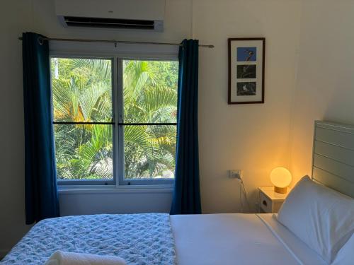 a bedroom with a bed and a large window at Kooyong Apartments, Arcadia in Arcadia