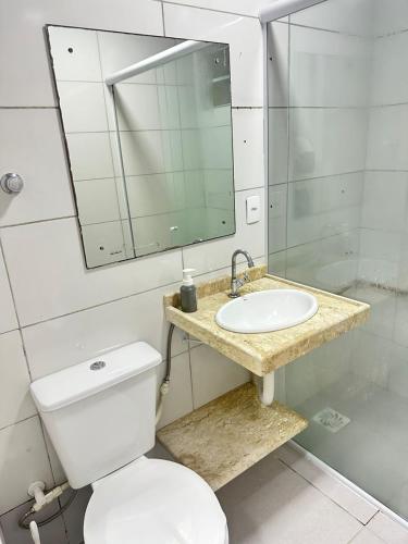 a bathroom with a toilet and a sink and a mirror at Suíte próximo a BR! in São José
