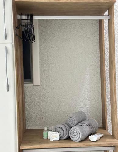 a shelf with towels in a kitchen with a mirror at Suíte próximo a BR! in São José