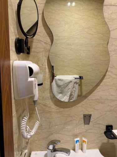 a bathroom with a hair dryer and a mirror at Italia Hotel Cairo in Cairo