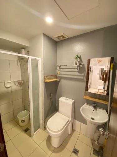 a bathroom with a toilet and a sink at Carlota247 in Cebu City