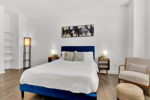 a bedroom with a blue and white bed and a chair at HEB 104 Spacious Condo Downtown Fort Worth, Free Parking, Gym in Fort Worth