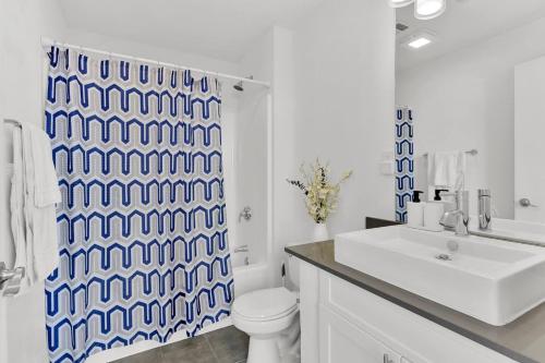 a bathroom with a toilet and a shower curtain at HEB 104 Spacious Condo Downtown Fort Worth, Free Parking, Gym in Fort Worth