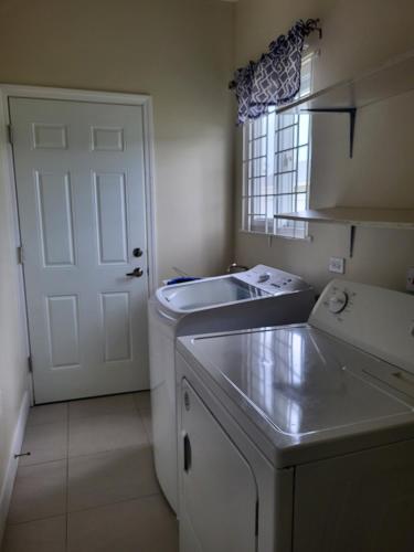 a small kitchen with a sink and a white door at Beit Elohim in Lucea