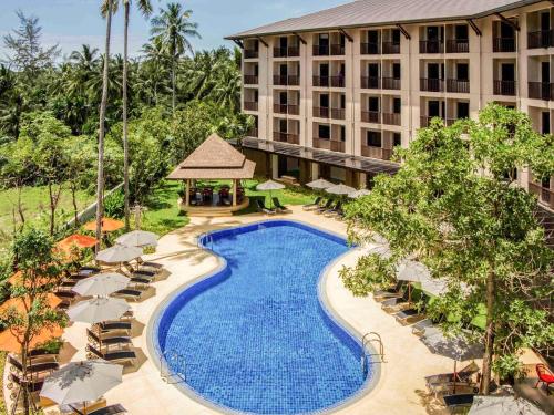 an overhead view of a hotel pool with chairs and umbrellas at ibis Styles Krabi Ao Nang in Ao Nang Beach