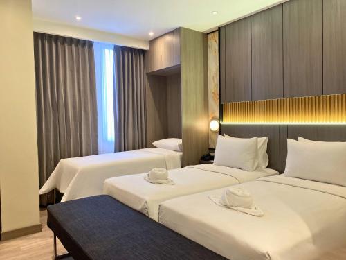 a hotel room with two beds with hats on them at Swiss-Belexpress Jemursari in Surabaya