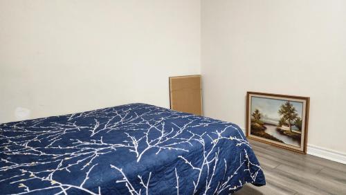 a bedroom with a bed and a picture on the wall at Guest suite with great comfort in Brampton