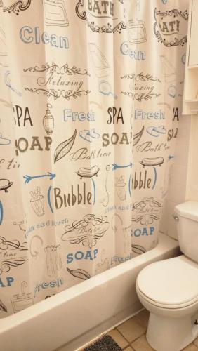 a bathroom with a shower curtain with writing on it at Guest suite with great comfort in Brampton