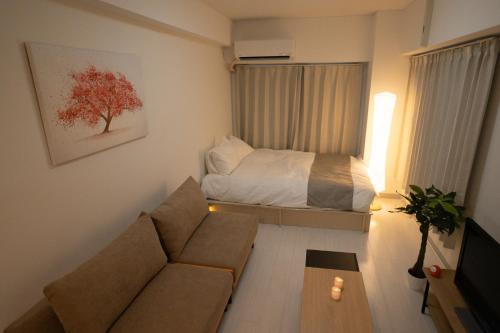 a living room with a couch and a bed at Park building Tenmonkan 1 in Kagoshima