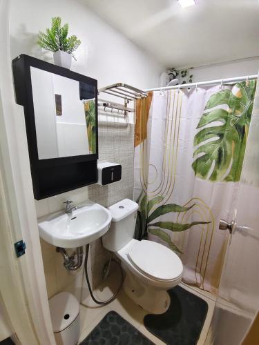 a bathroom with a toilet and a tv on the wall at Balay Madayaw in Davao City