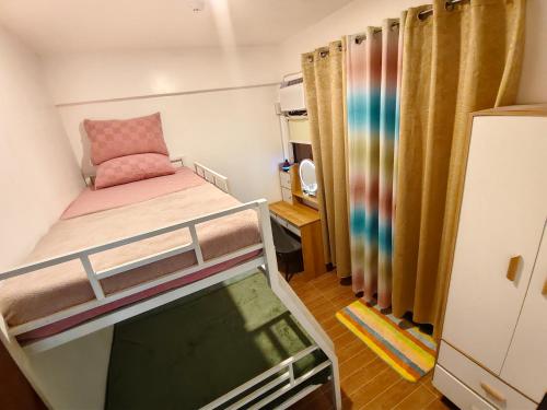 a small room with a bunk bed and a tv at Balay Madayaw in Davao City
