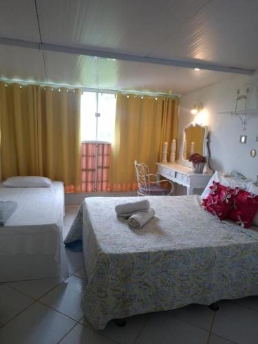 a hotel room with two beds and a mirror at Pousada Brasil Tropical in Bezerros