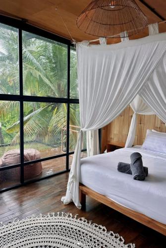 a bedroom with a bed with a canopy at SPICE TRADER in Nusa Penida