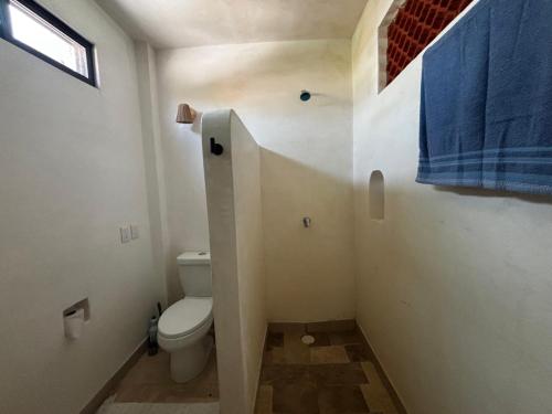 a bathroom with a toilet and a blue towel at The perch in Puerto Escondido