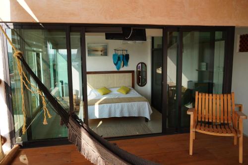 a balcony with a bed and a hammock in a room at The perch in Puerto Escondido
