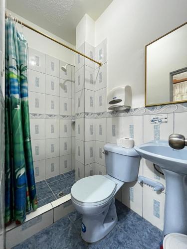 a bathroom with a toilet and a sink at Hostal Amazónico Bello Amanecer in Nueva Loja