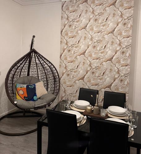a dining room with a swing chair and a table at Walsall Comfort Home 3Bedroom Retreat Sleeps 6 in Bescot