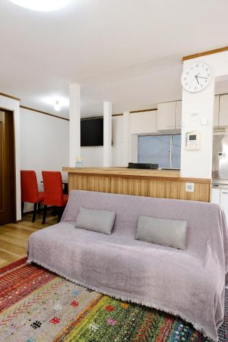 a bedroom with a bed and a clock on the wall at Cozy Pad in Tokyo