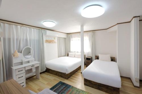 a bedroom with two beds and a mirror at Cozy Pad in Tokyo