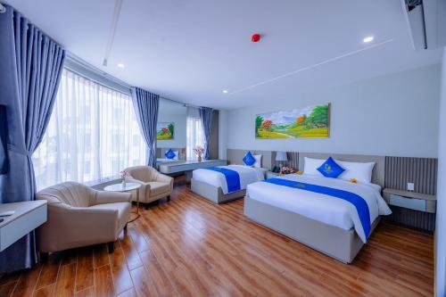 a bedroom with two beds and a living room at Cannes Ben Tre Hotel in Ben Tre