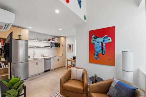 a living room with two chairs and a kitchen at Hotel SOMA in Fort Worth