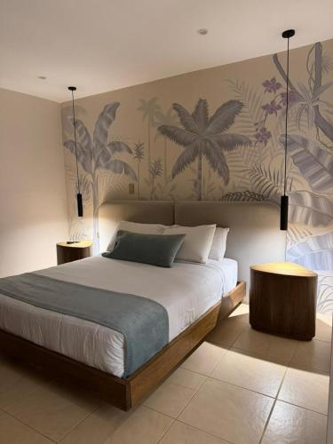 a bedroom with a large bed with a tropical wallpaper at El Zócalo Hotel Boutique in Filandia