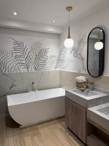a bathroom with a large white tub and two sinks at El Zócalo Hotel Boutique in Filandia