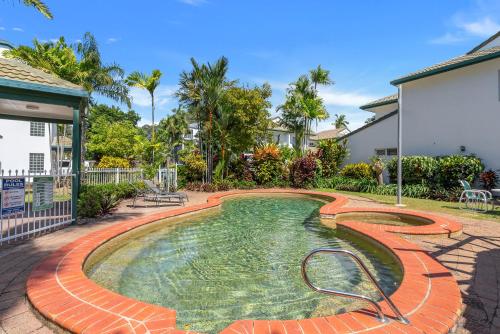 a swimming pool in the backyard of a house at Costa Royale Beachfront Apartment in Trinity Beach