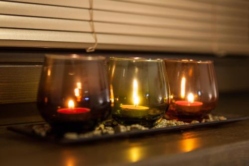 three glasses with candles in them on a table at Apartman Chopok Juh Ema Superior in Tale