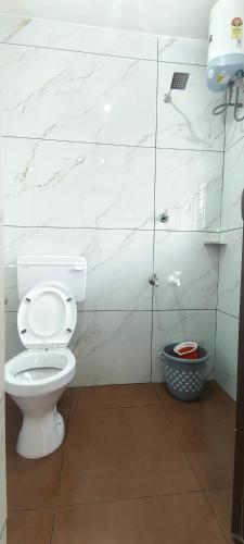 a bathroom with a white toilet and marble walls at Beach Bum Varkala in Varkala