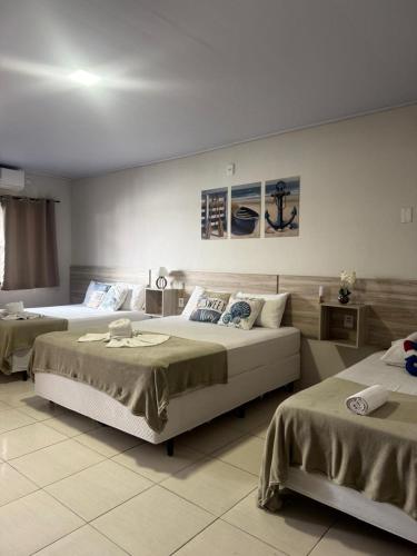 a bedroom with two beds and two tables at Pousada Villa do Mar in Penha