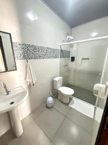 a bathroom with a sink and a toilet and a shower at Pousada Villa do Mar in Penha