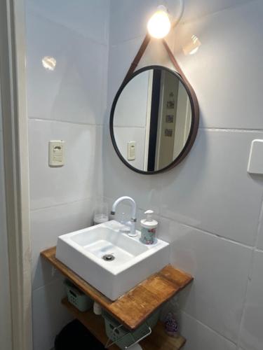 a bathroom with a white sink and a mirror at Cafofo da Rosane in Pelotas