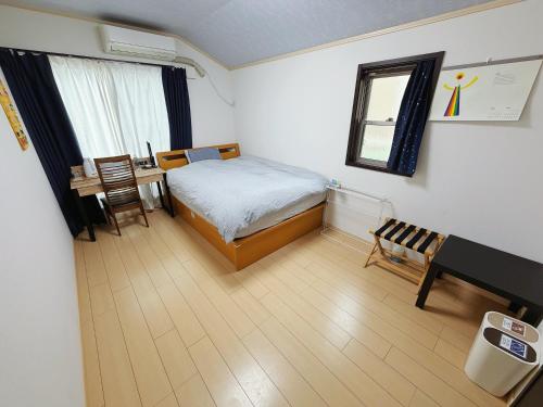 a bedroom with a bed and a desk and a table at Hao Bros. Home in Tokyo